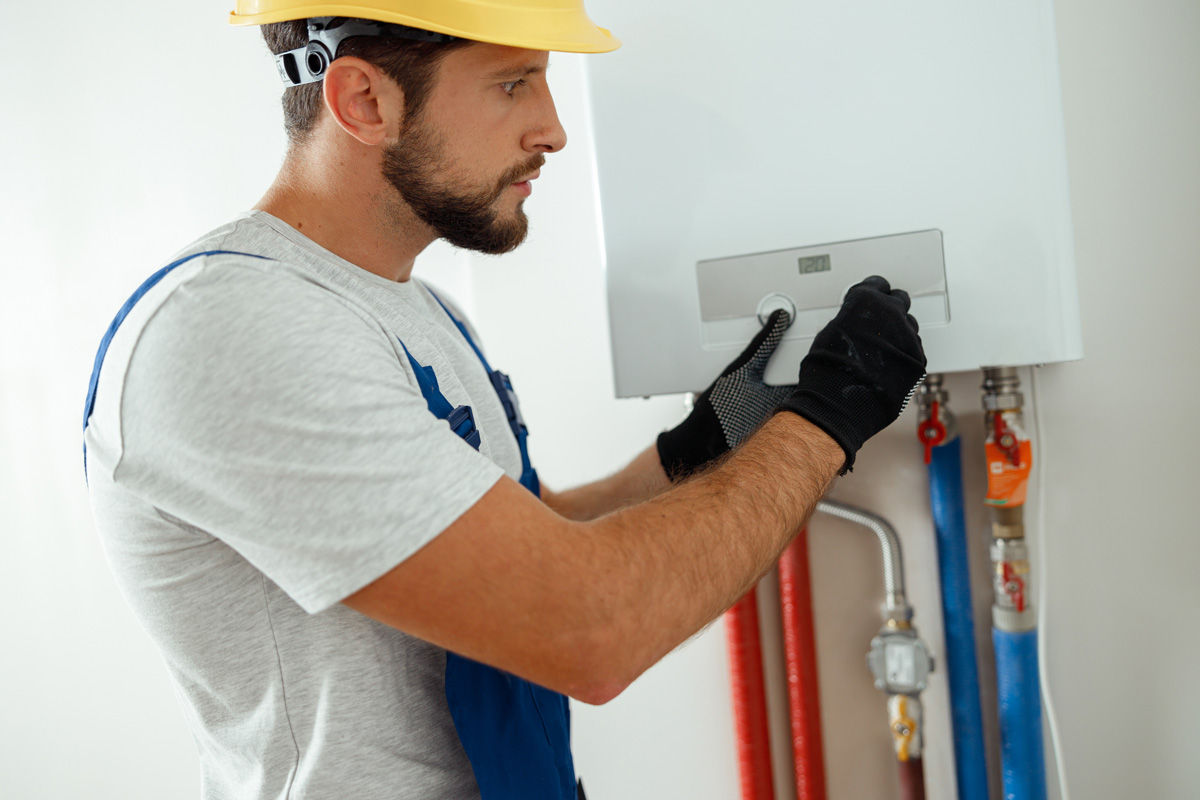 Technician installing a gas boiler heating system